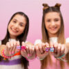 Picture of two girls looking happy and holding up their Clickeez